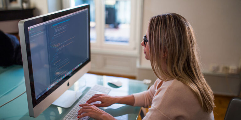 How to Preserve & Admit Social Media Evidence - Photograph of woman sitting at desk in front of a computer.